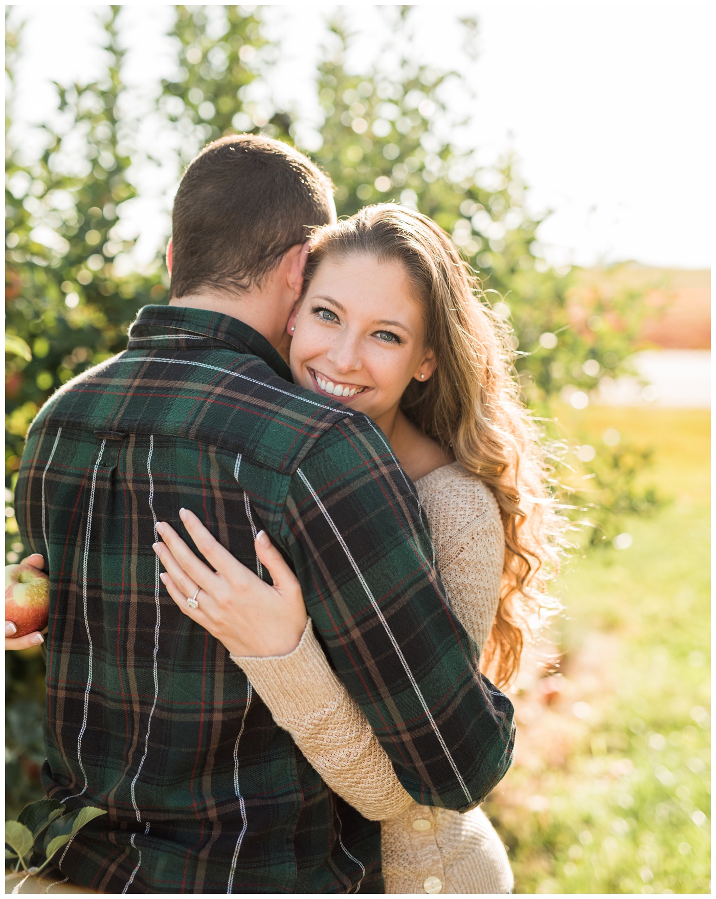Engaged couple dancing in an apple orchard 