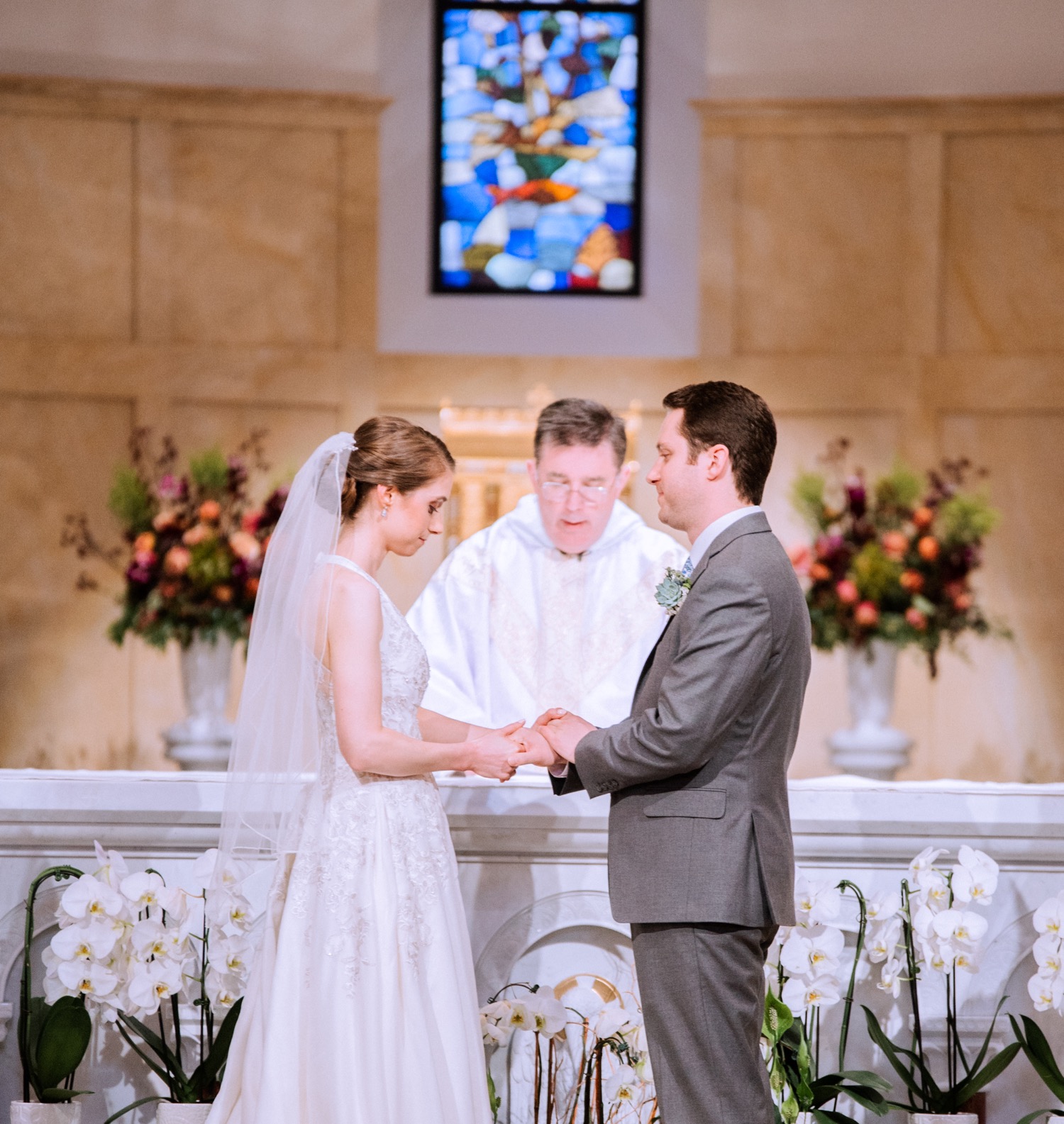 bride and groom look into each others eyes and hold hands at alter