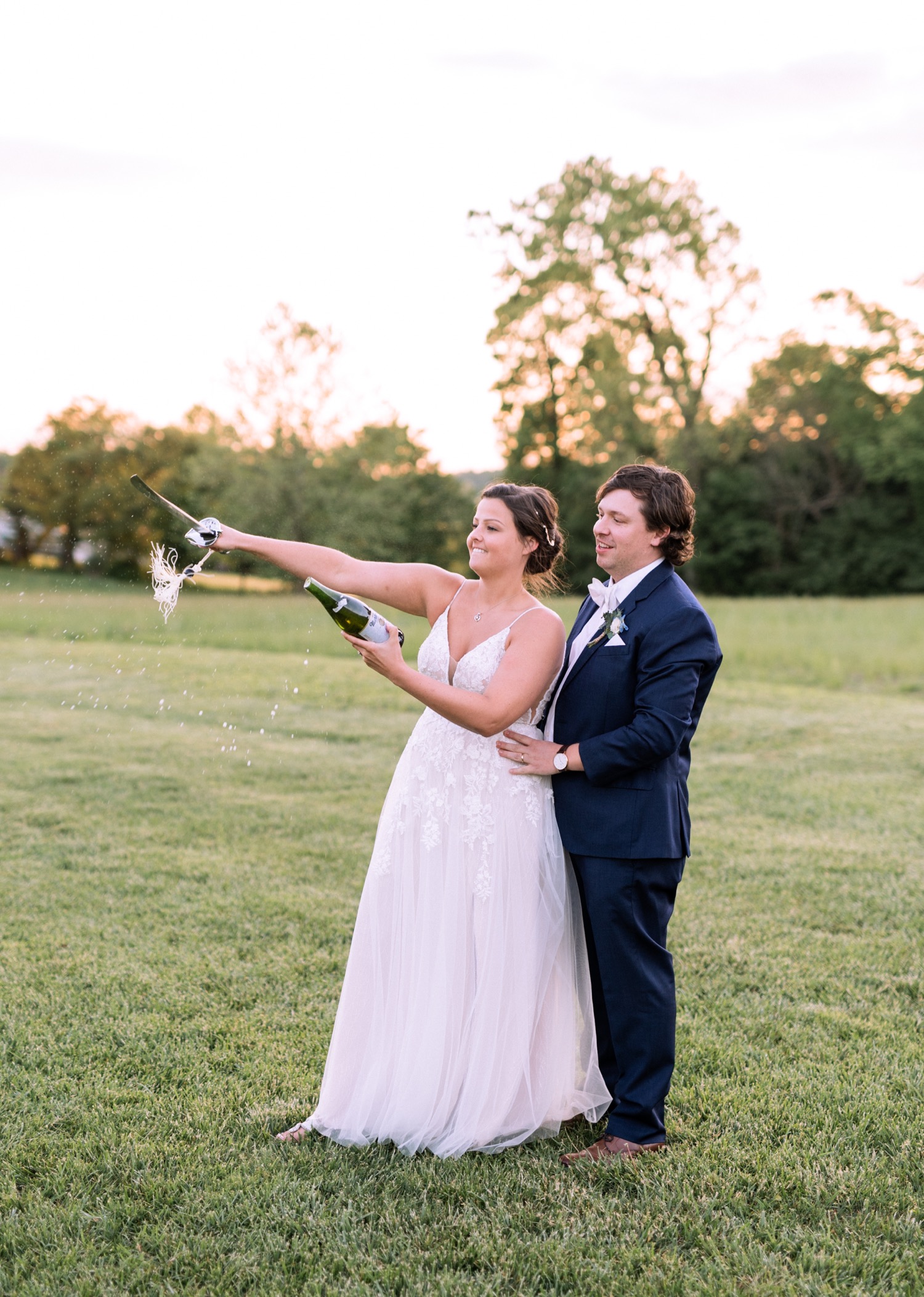 bride and groom open champagne with machete at Glen Ellen Farm wedding