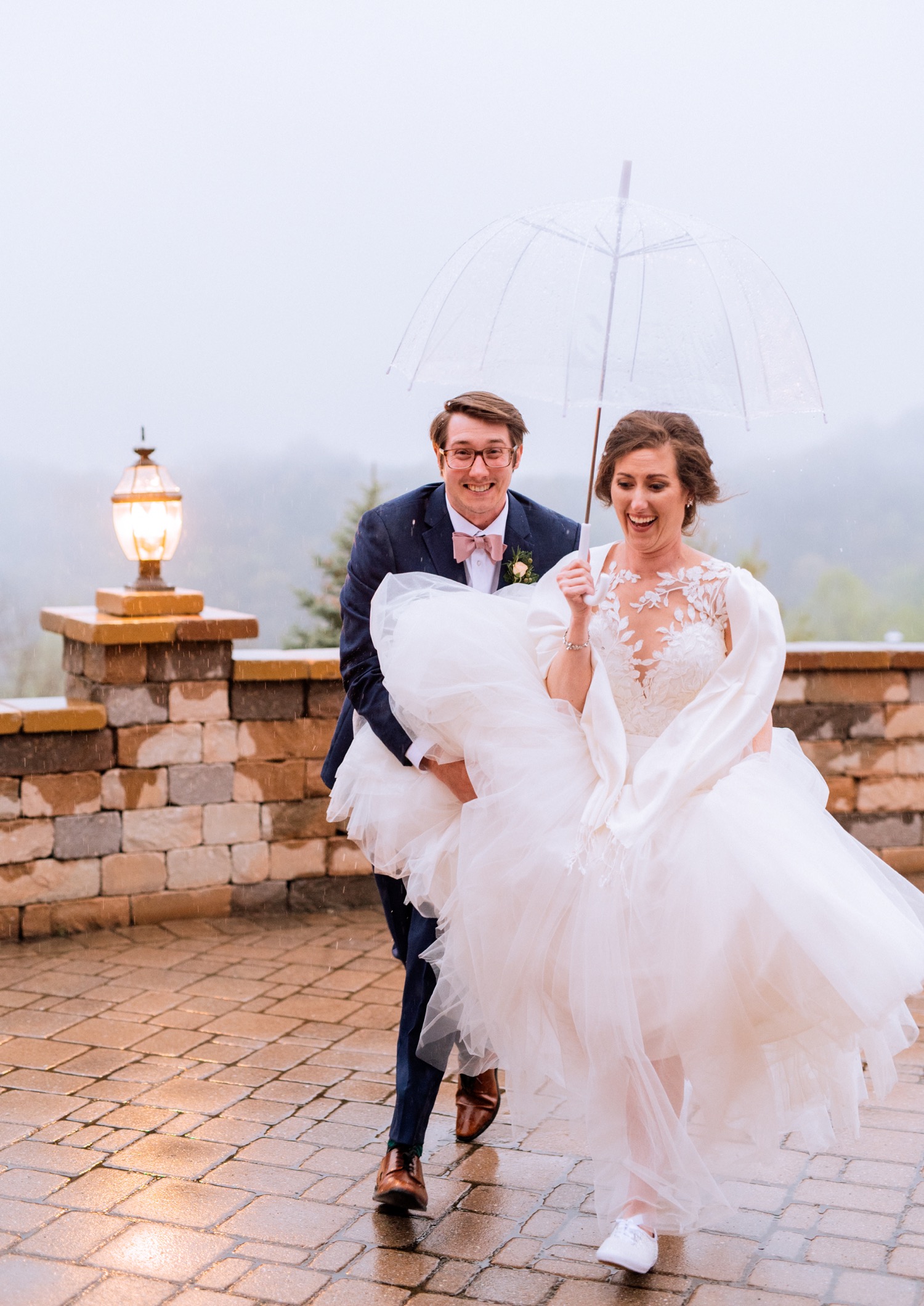 Bride and groom laugh in the rain at Irvine Estate