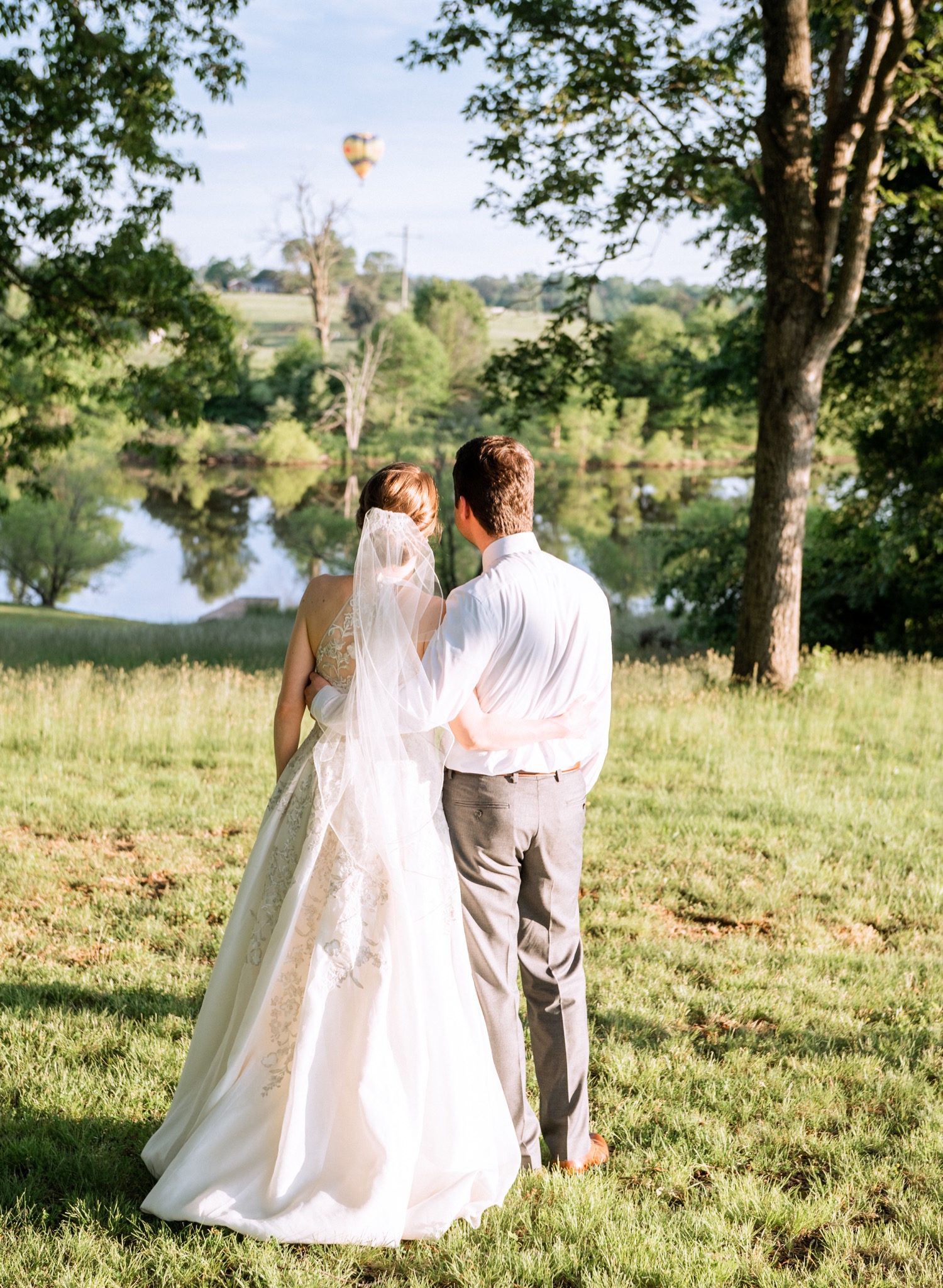 bride and groom look out over pond 