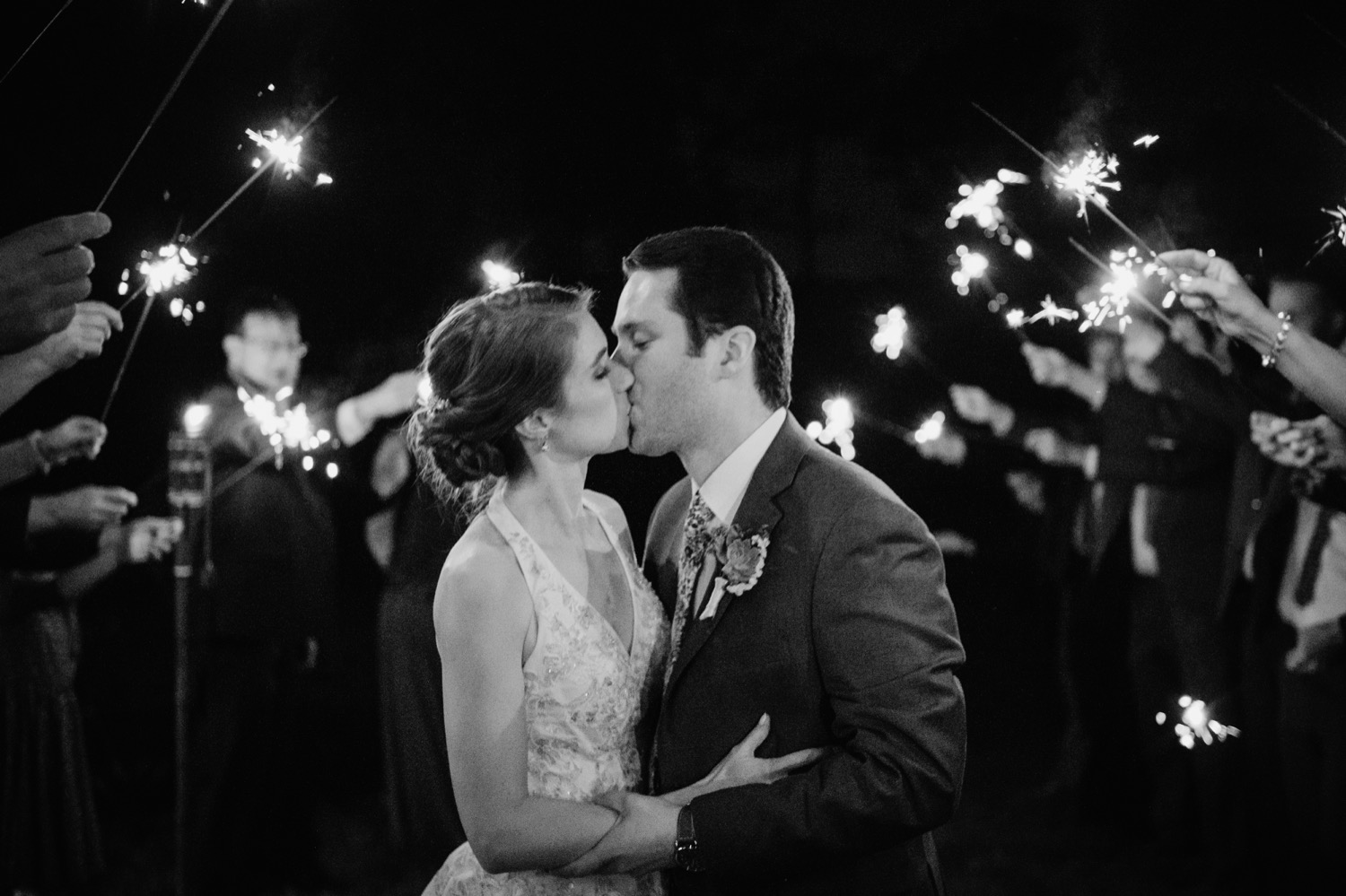 bride and groom kissing during sparkler sendoff