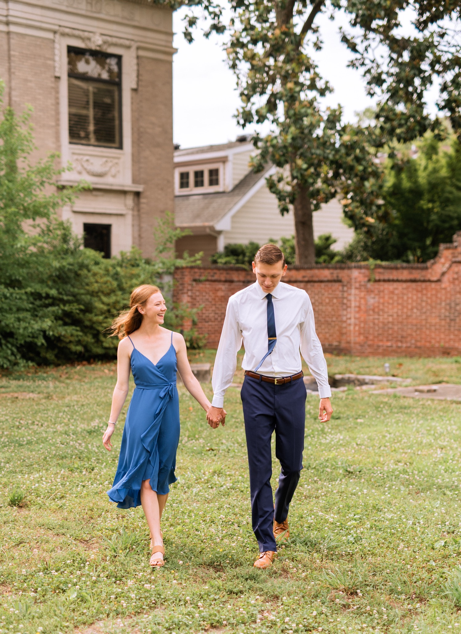 engaged couple hold hands during engagement shoot in the freeman historic district in norfolk virginia