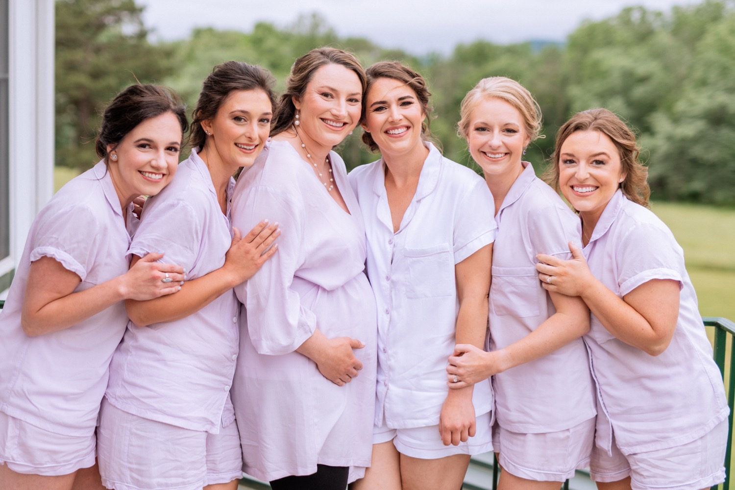 Bride and bridesmaids lined up in matching pajamas before getting into dresses