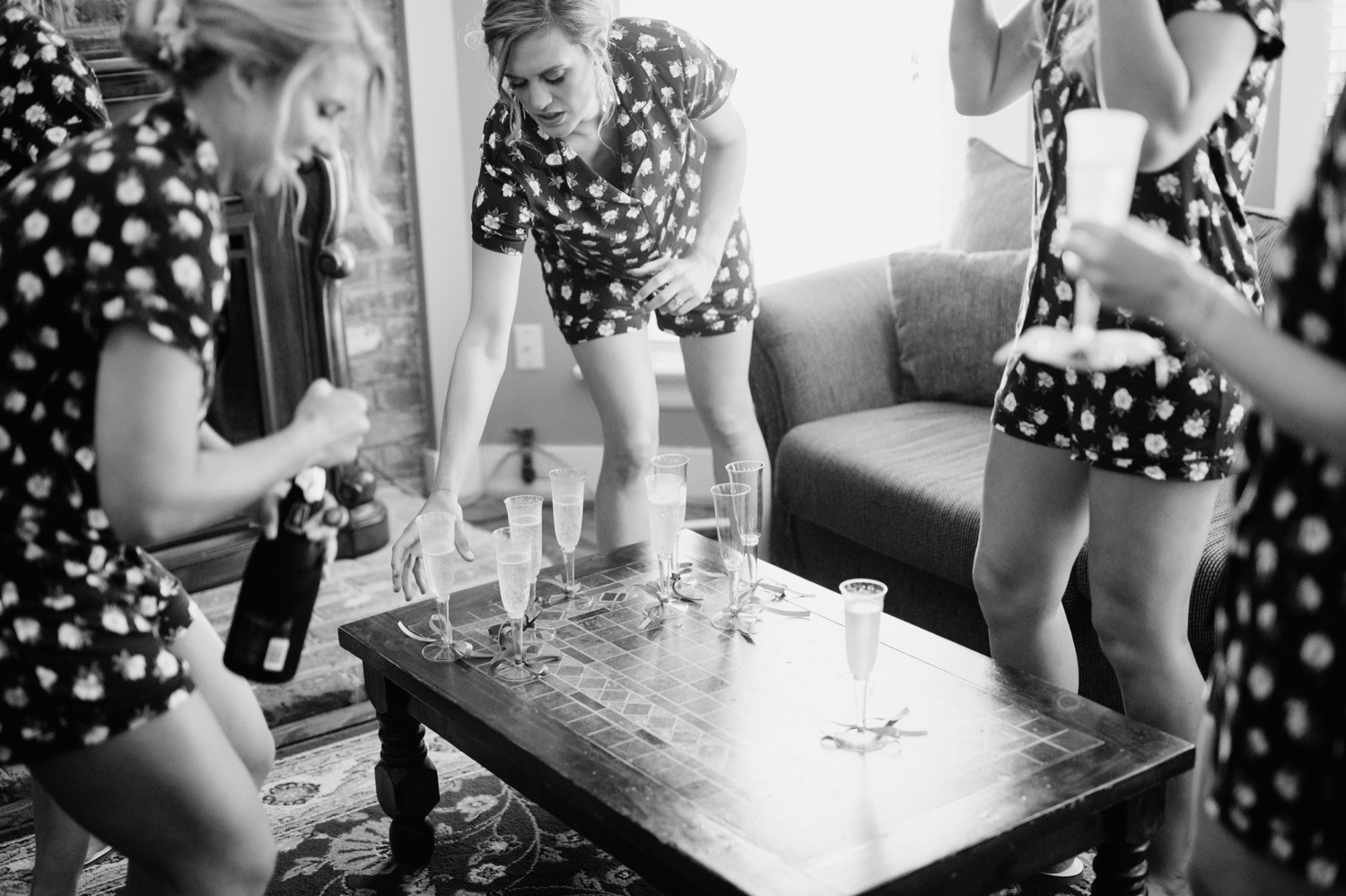 Bride in polka dot pajamas popping champagne while getting ready for her wedding ceremony in Richmond, Virginia