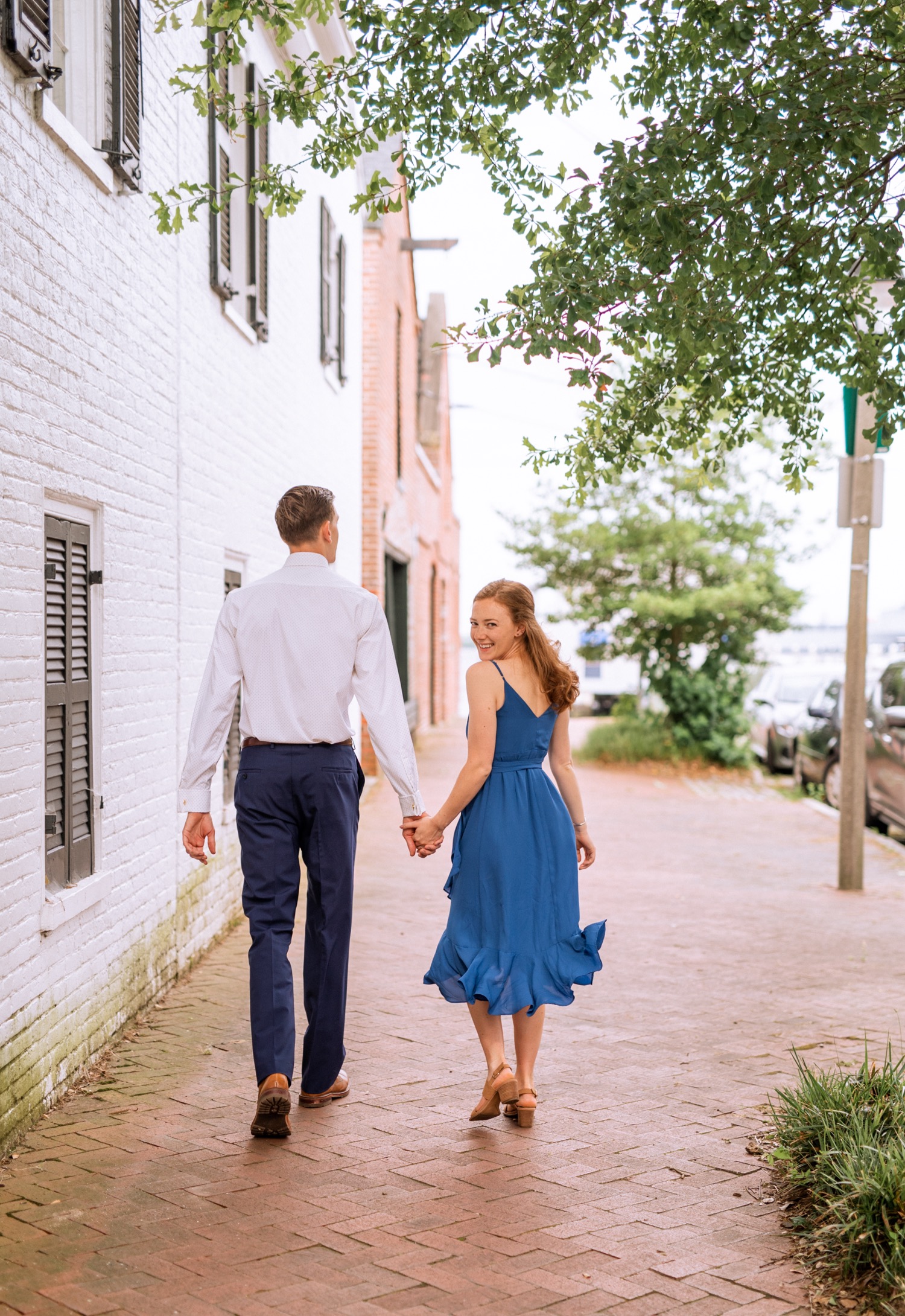 engaged couple walks down brick road during engagement shoot in the freeman historic district in norfolk virginia