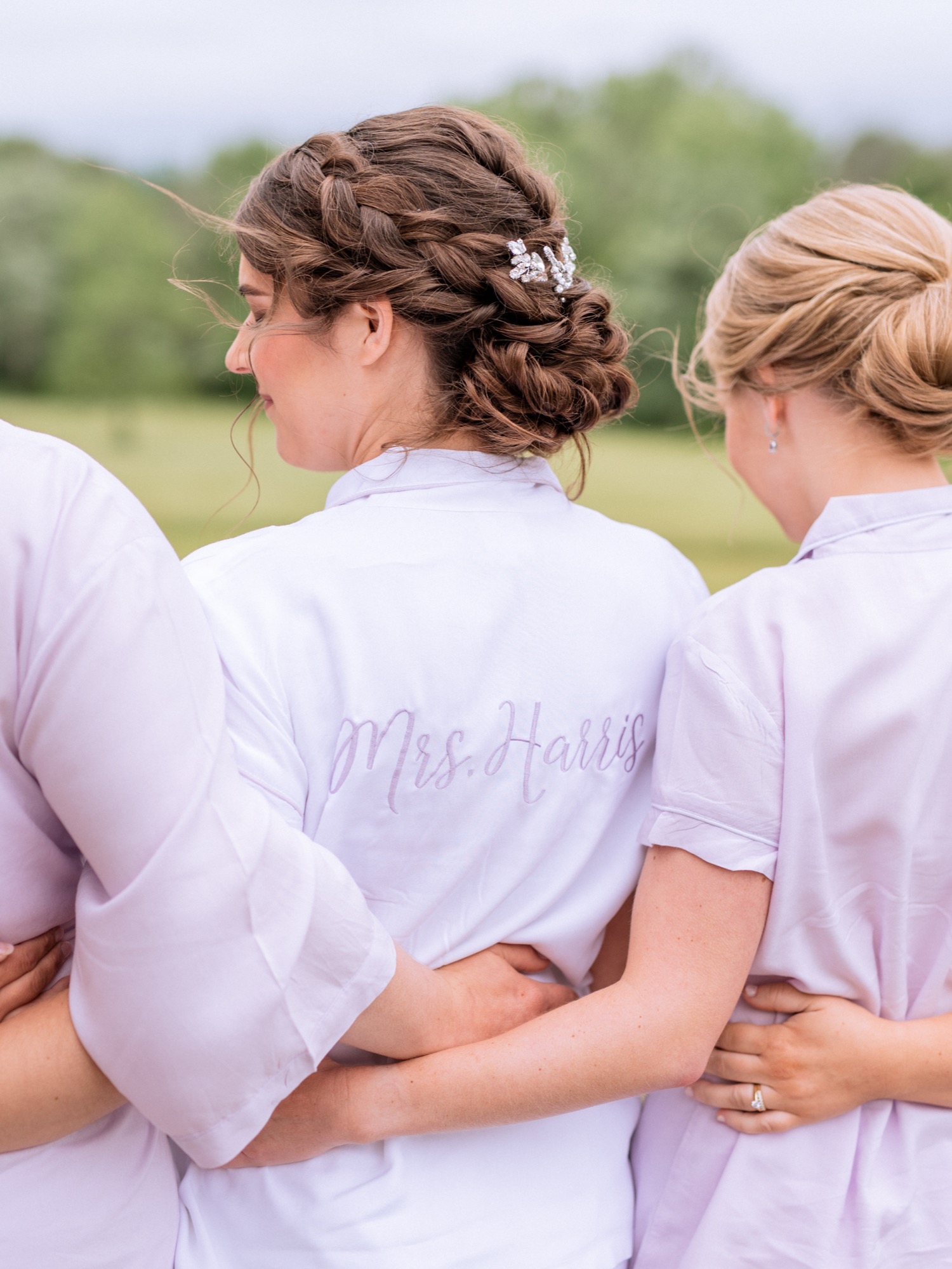Bridesmaids hugging bride in her robe before she gets her wedding dress on