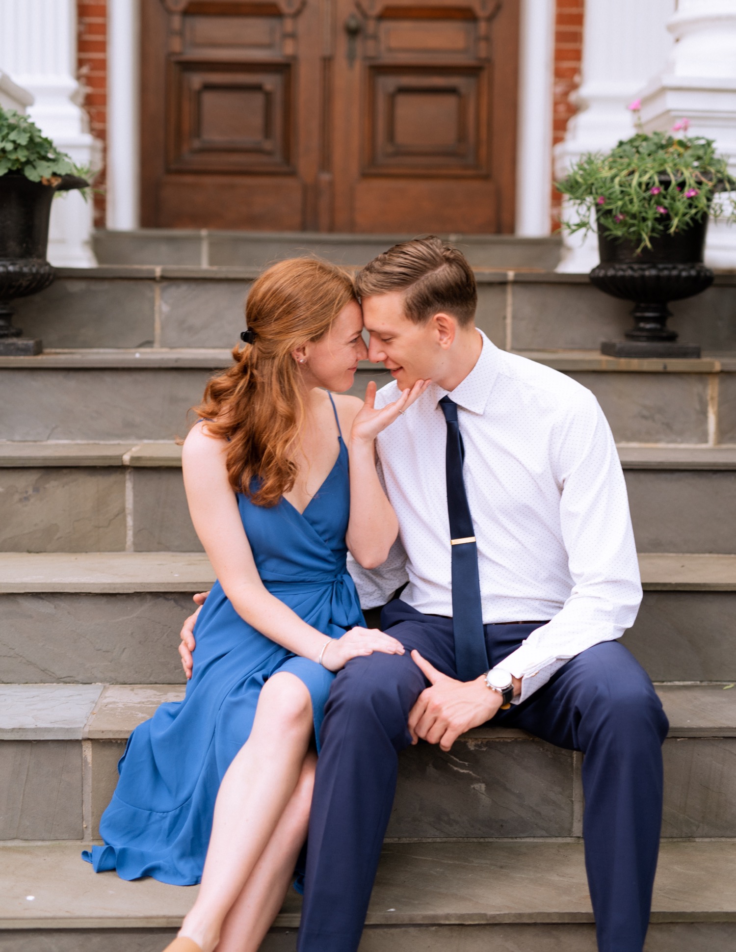 engaged couple hold each other close on staircase during engagement shoot in the freeman historic district in norfolk virginia