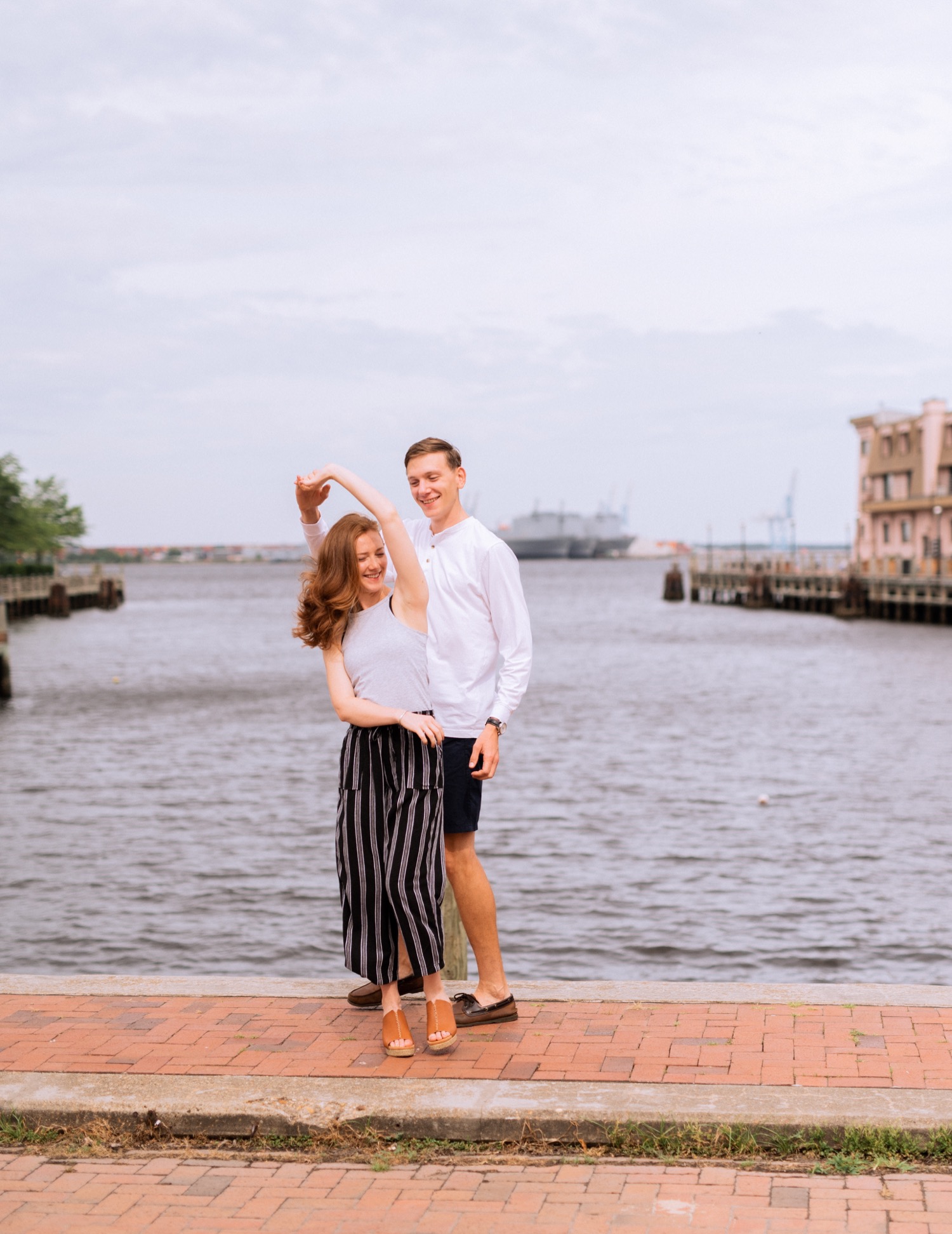 engaged couple dancing on waterfront in the freeman historic district in Norfolk Virginia engagement session