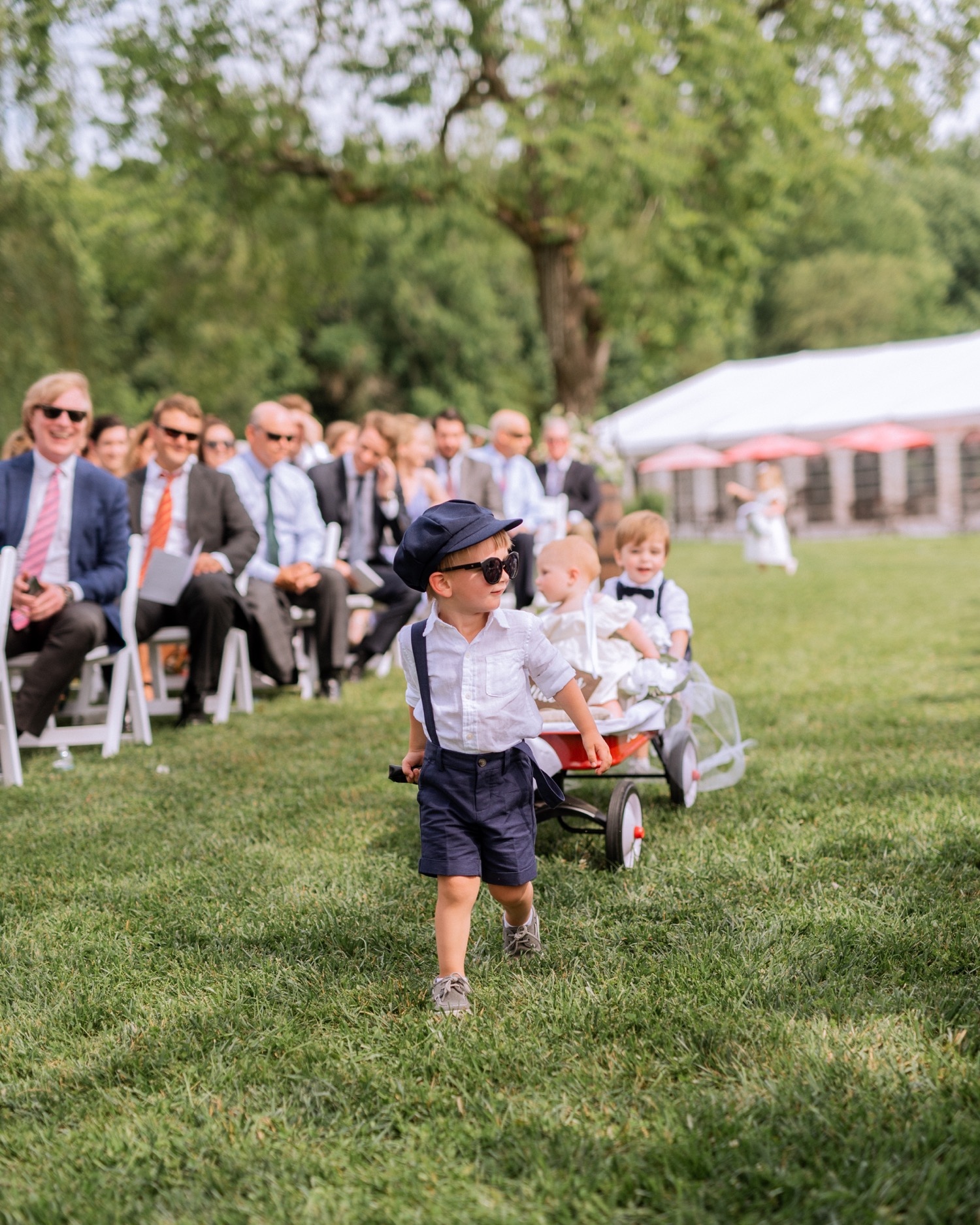 Ring bearers and flower girl making their way down the aisle before the bride during summer wedding in Richmond, Virginia
