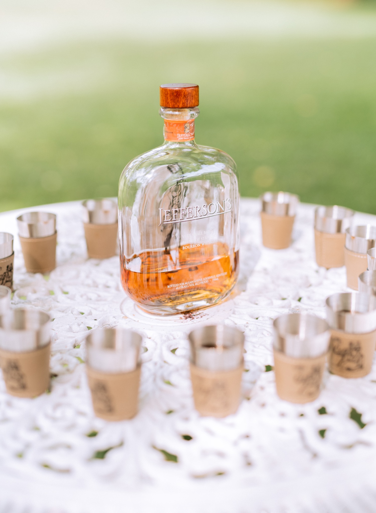 Bottle of bourbon and shot glasses ready for the wedding party to celebrate after the wedding ceremony at Amber Grove in Richmond, Virginia
