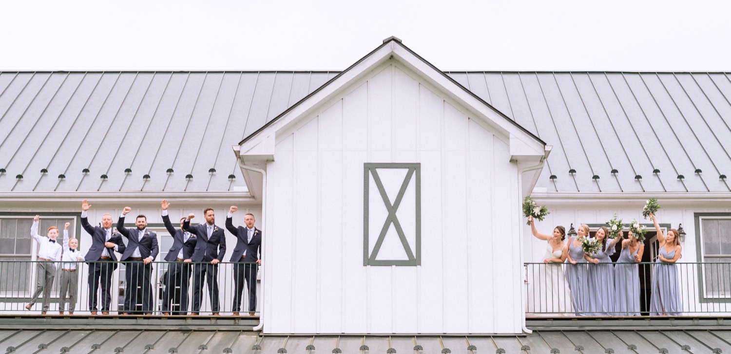 Entire wedding party on the balcony of the barn at Edgewood before the wedding ceremony begins