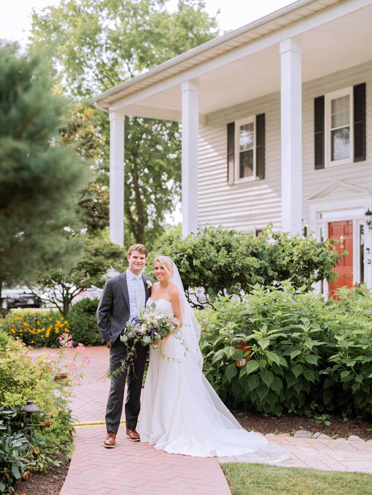 Bride and groom celebrating their wedding day in front of their venue- Amber Grove in Richmond, Virginia
