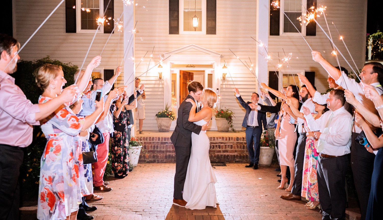 Bride and groom kissing during the sparkler send off after their summer wedding at Amber Grove in Richmond, Virginia