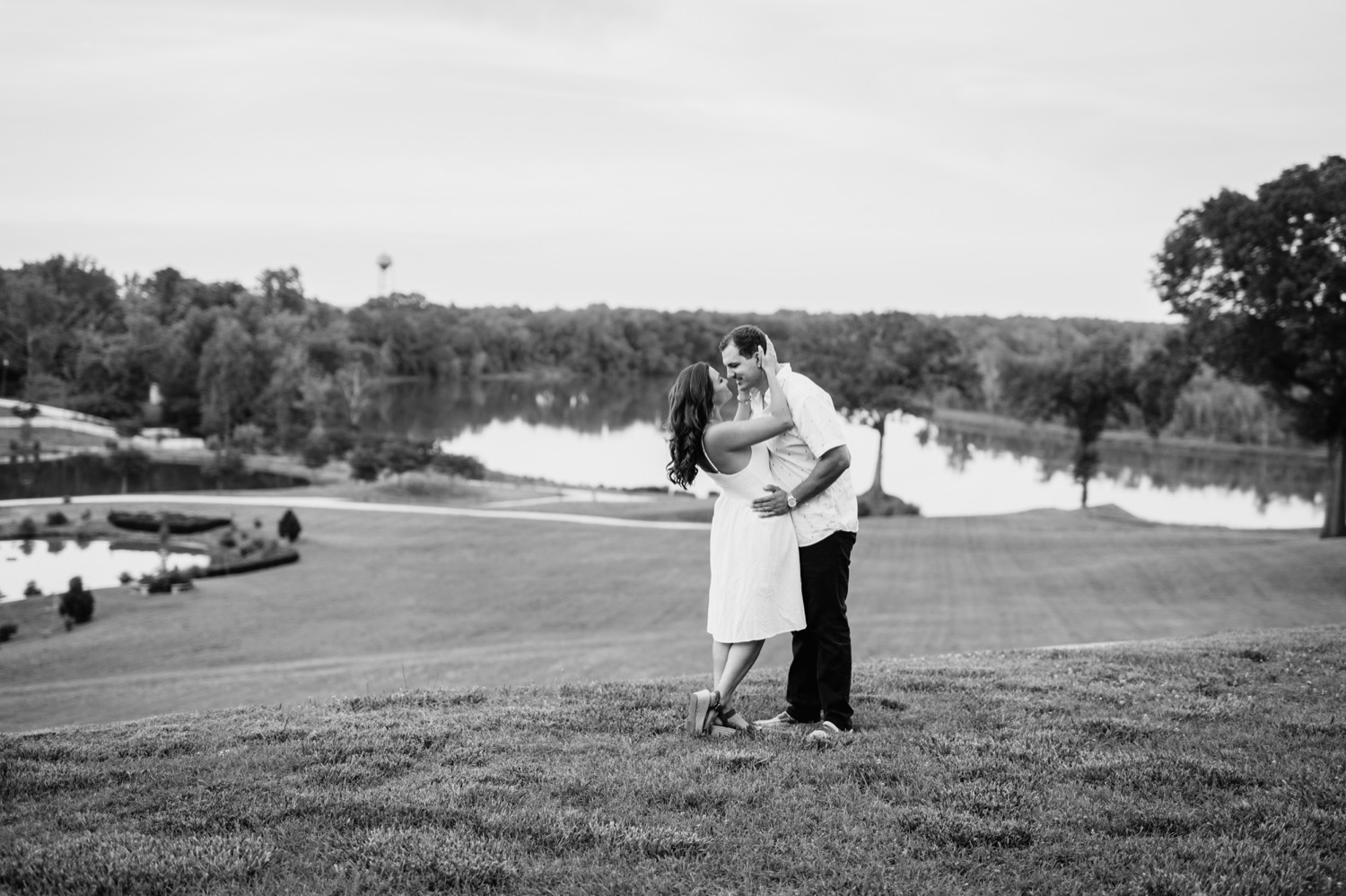 engaged couple kissing in front of the lake at the cumberland estate in richmond virginia