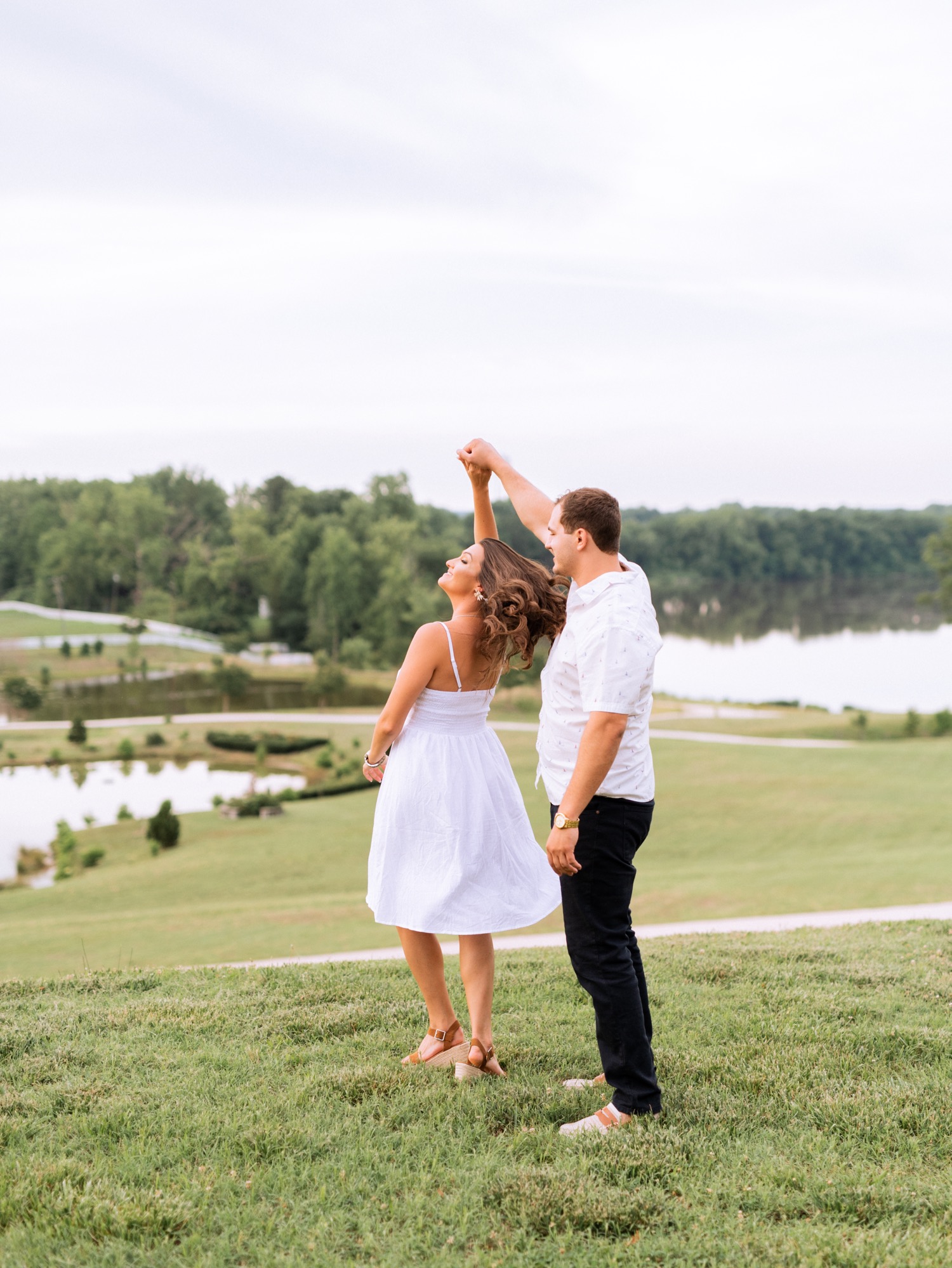 engaged couple dancing in front of the lake at the cumberland estate in richmond virginia