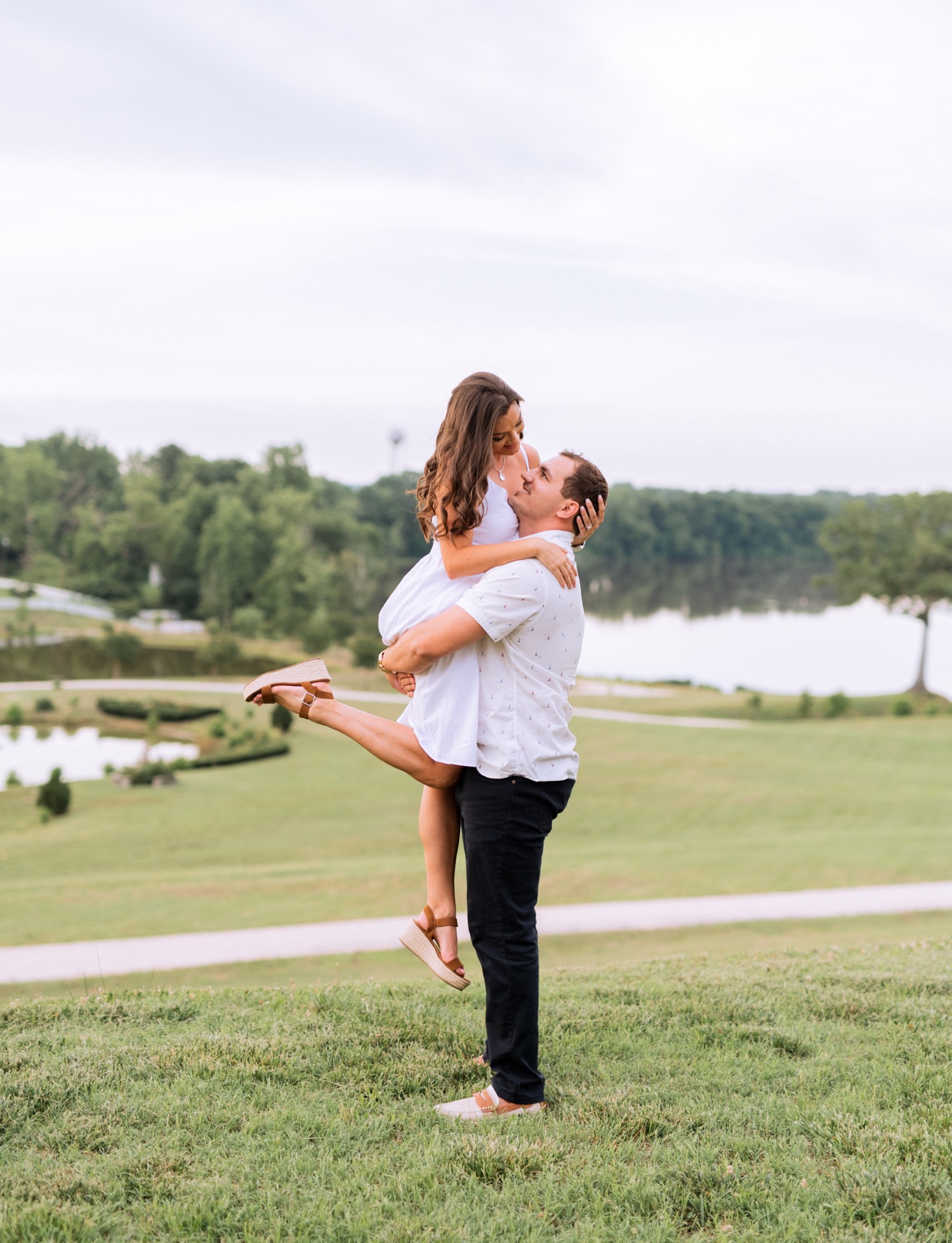 engaged couple dancing in front of the lake at the cumberland estate in richmond virginia