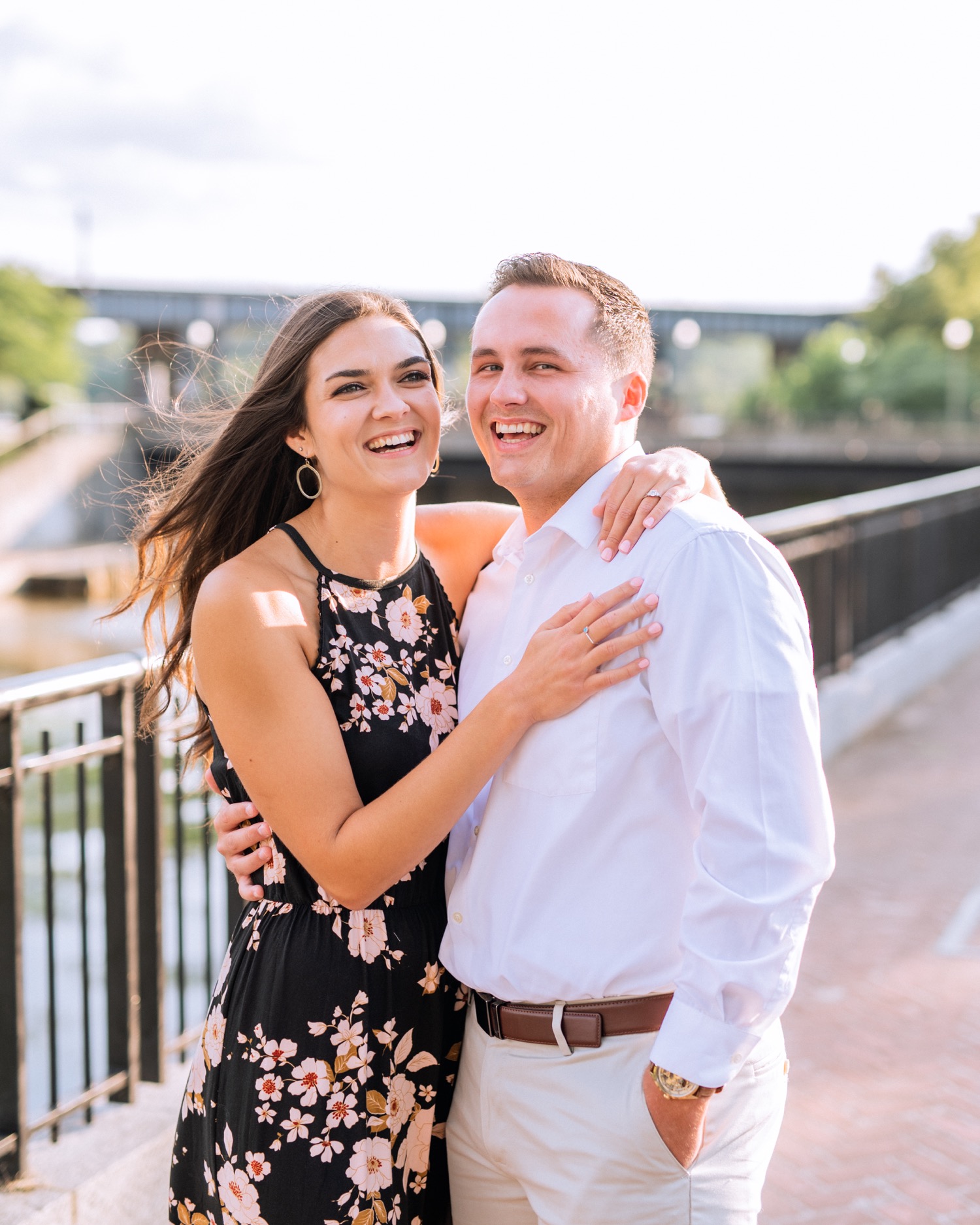 engaged couple in long dress and white button down with khakis standing along the waterfront in browns island