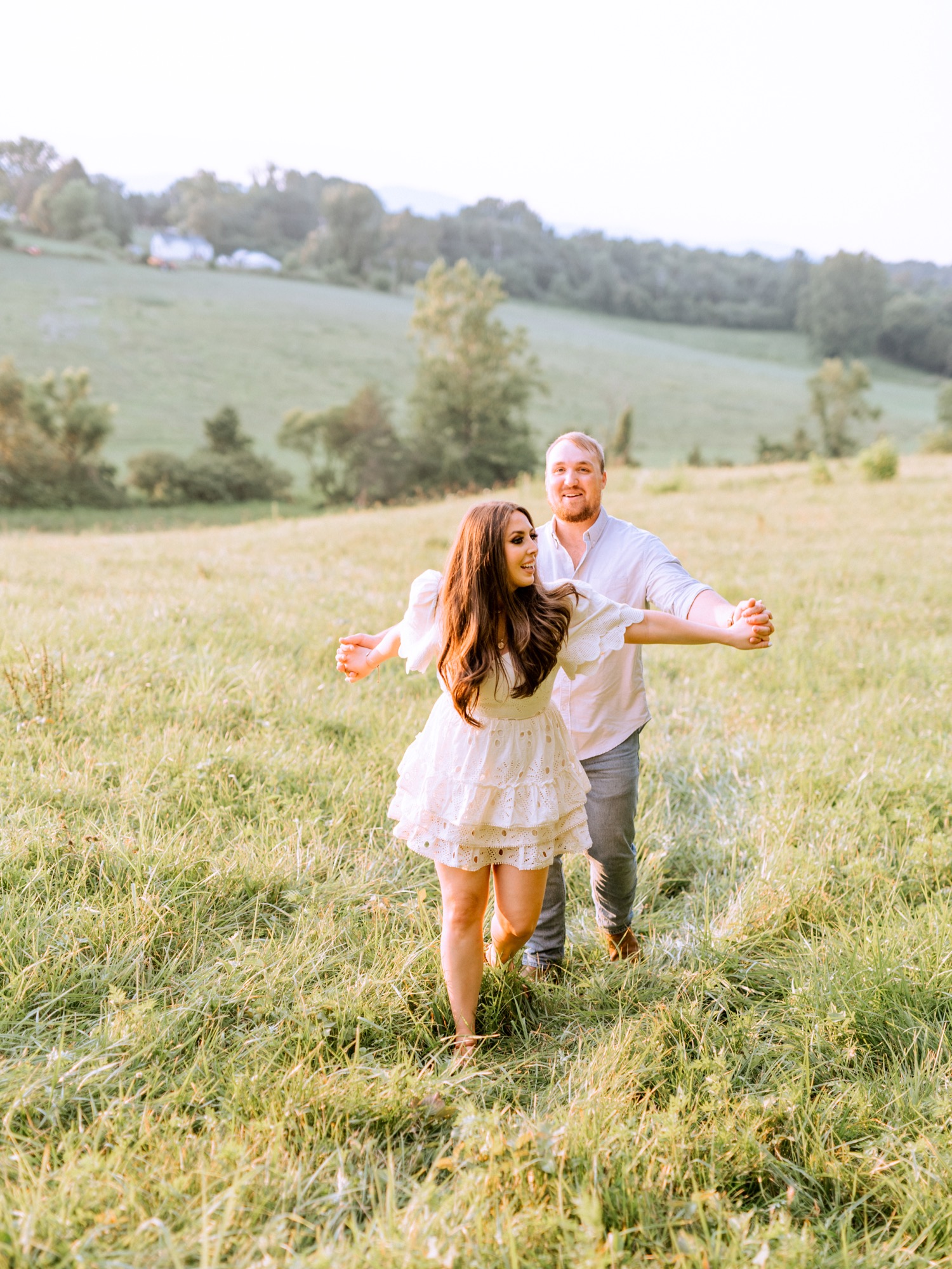 engaged couple dancing in the rolling hills and cow filled pastures of Madison Virginia