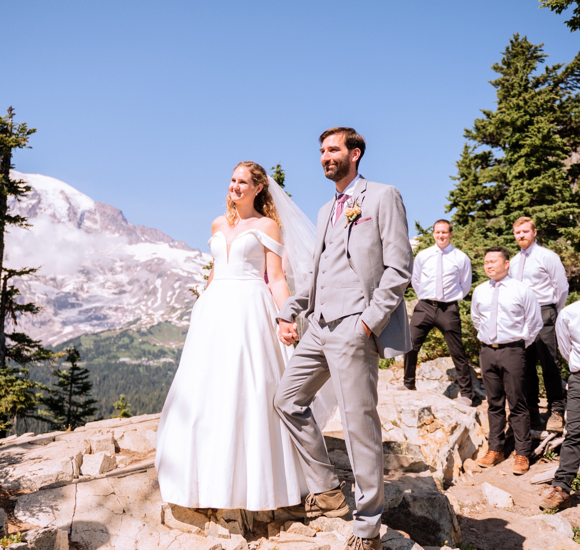 bride and groom with groomsmen behind them on top of mt rainier