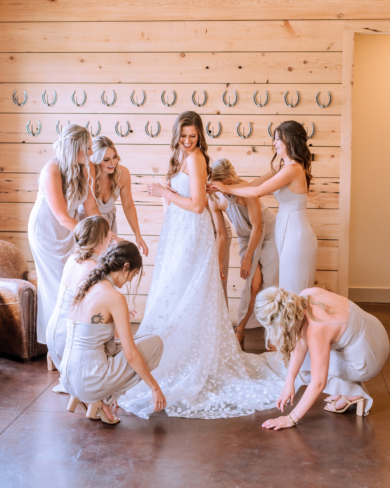 bride and bridesmaids in their gowns putting on the finishing touches before they head to the ceremony 