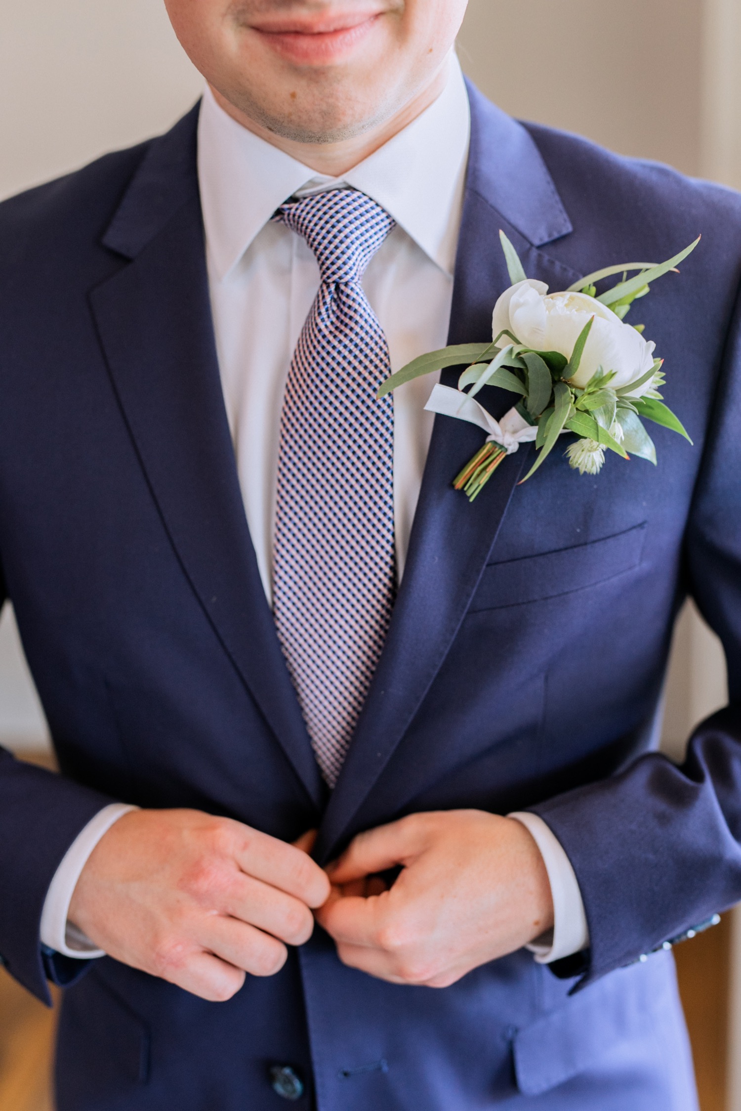 close up of the groom in his blue tux before the first look on wedding day