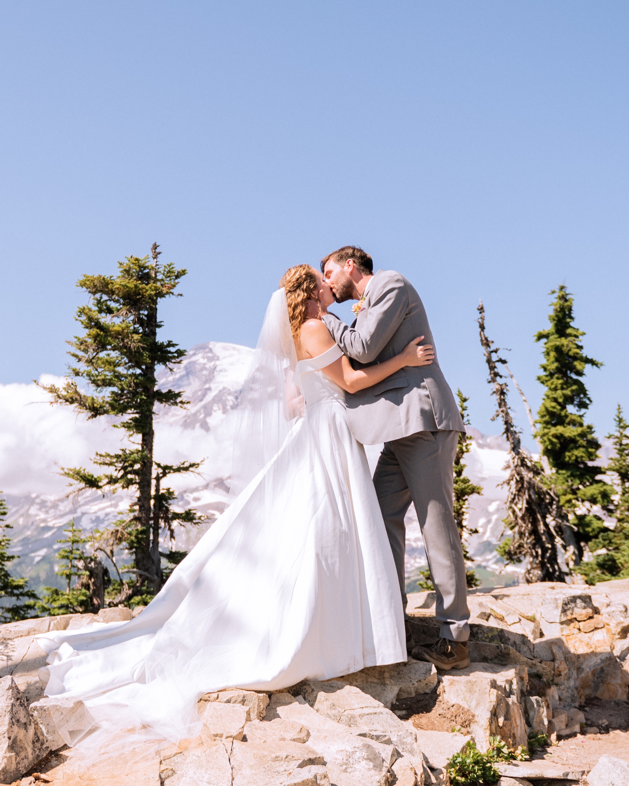 bride and groom kiss during elopement ceremony on top of mt rainier