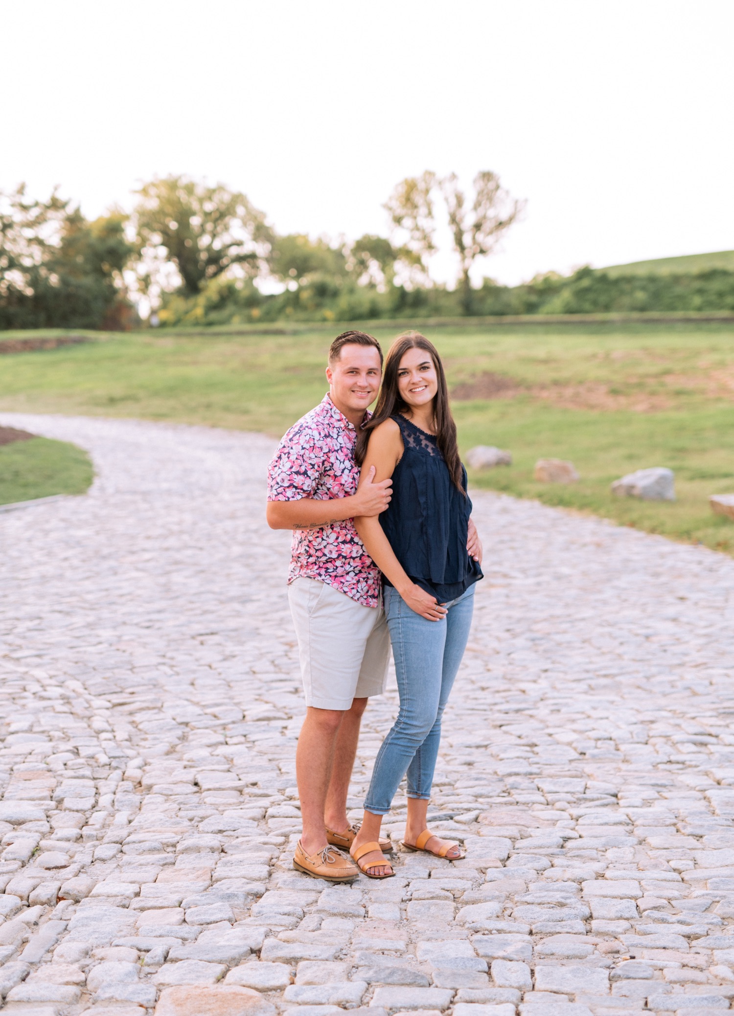 engaged couple stands on stone walkway outside of richmond virginia