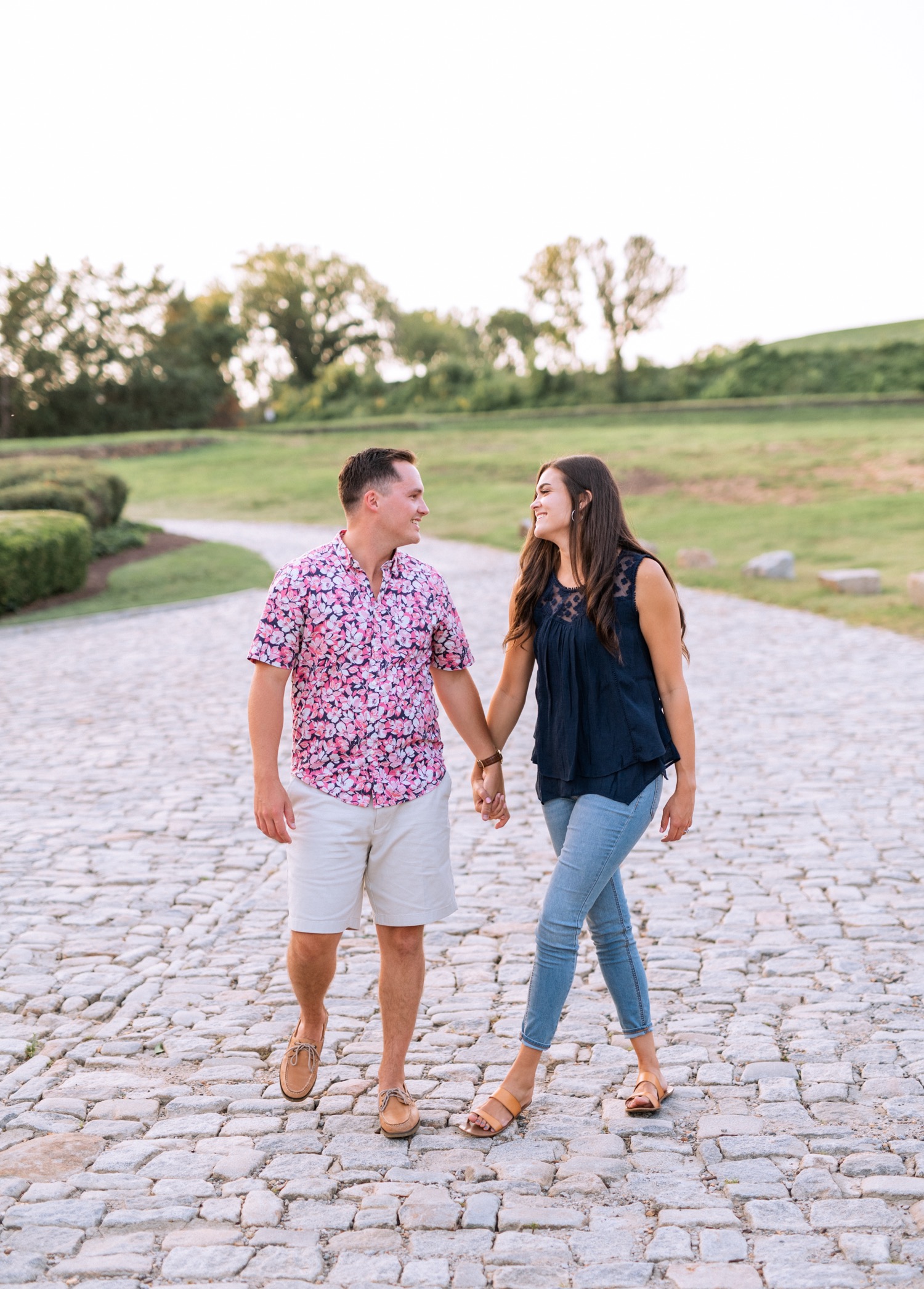 engaged couple stands on stone walkway outside of richmond virginia