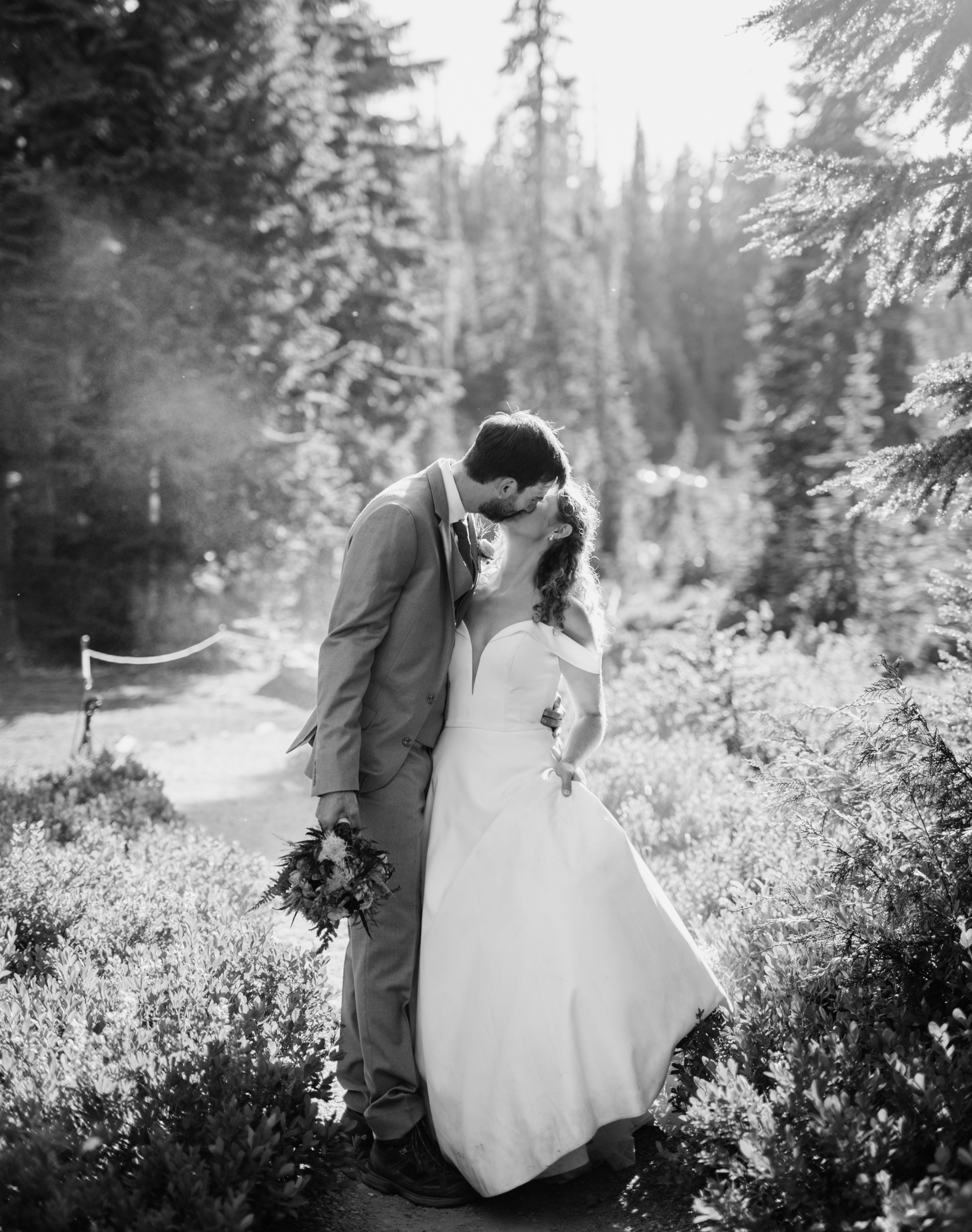 bride and groom kissing in the forest inside of mt rainier national park