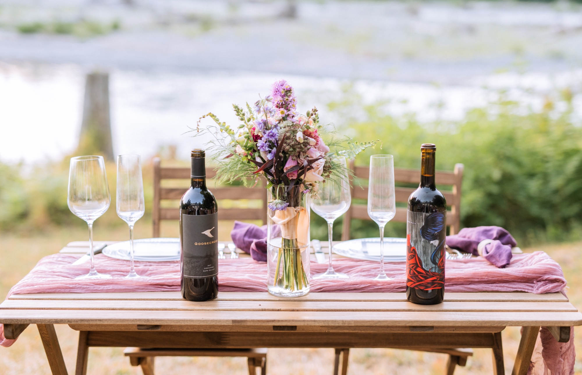 table set with wine bottles and purple flowers