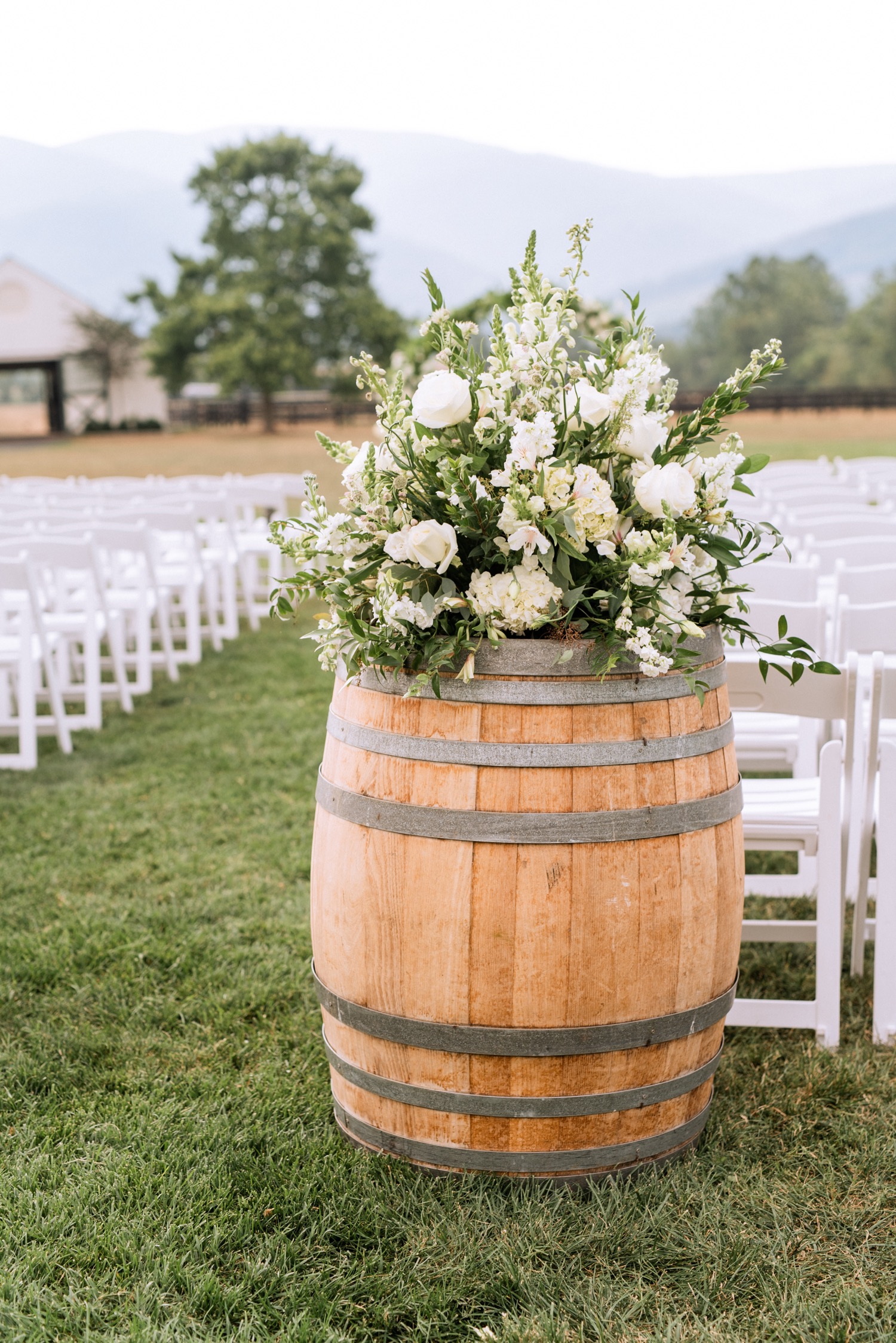 white floral arrangement on top of a barrel at the King Family Vineyards Charlottesville wedding venue