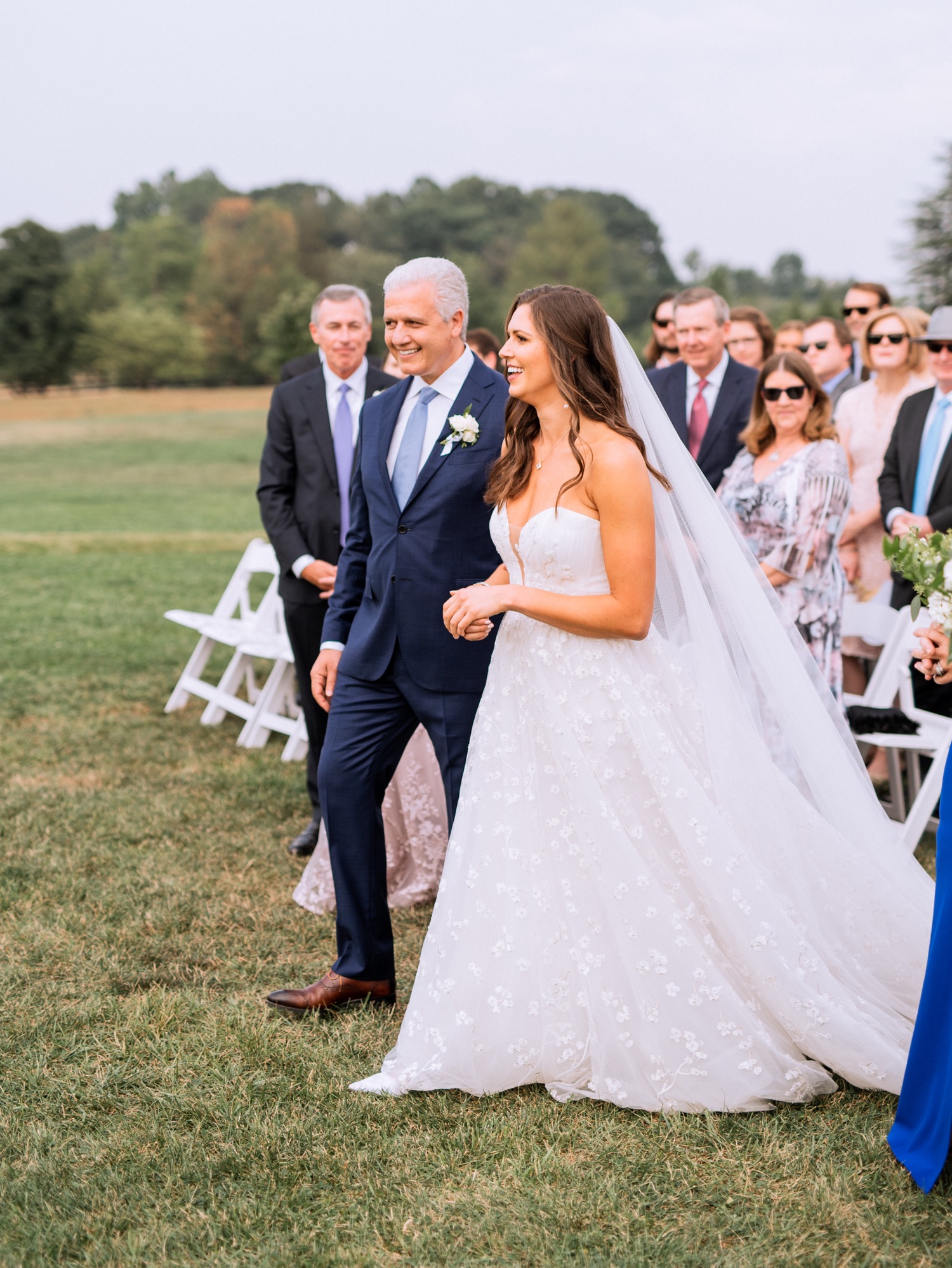 bride walking down the aisle with her dad escorting her