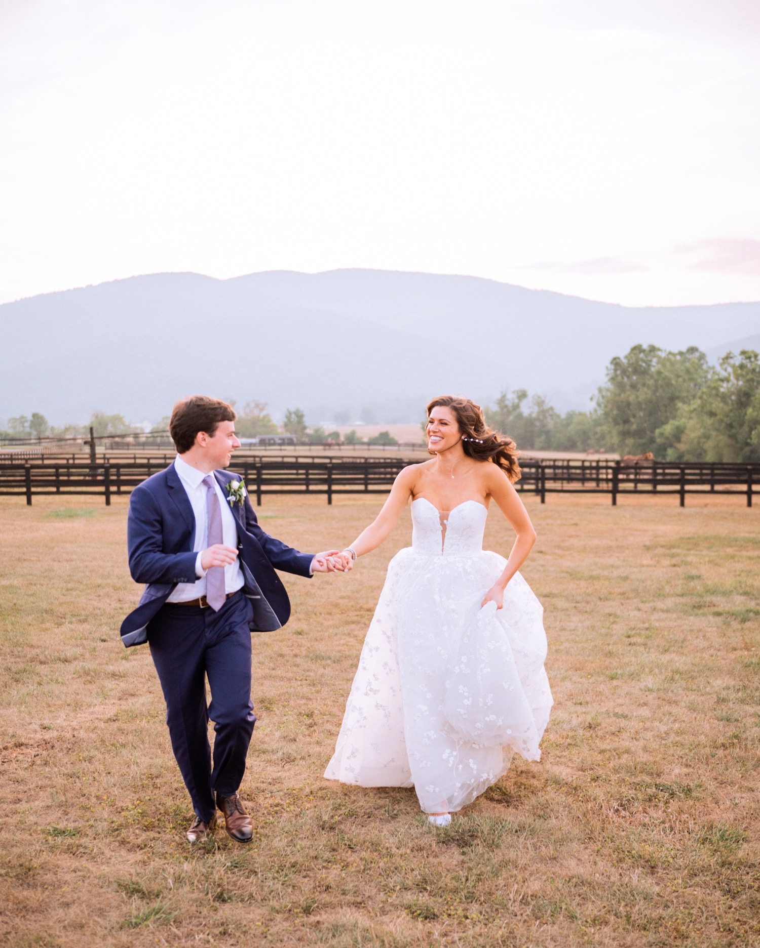 bride and groom running through the vineyard on their Charlottesville wedding day