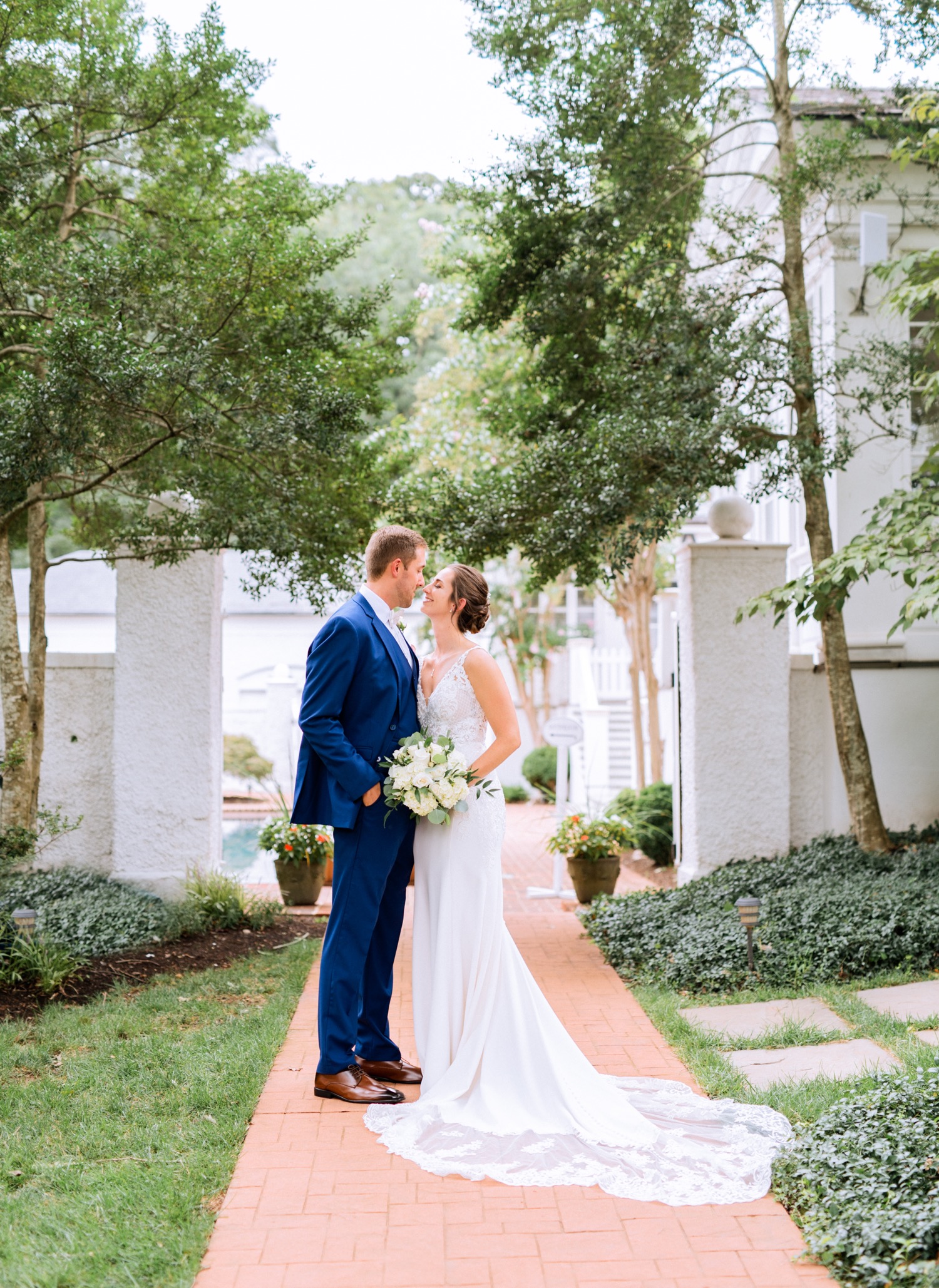 bride and groom kissing on a brick pathway