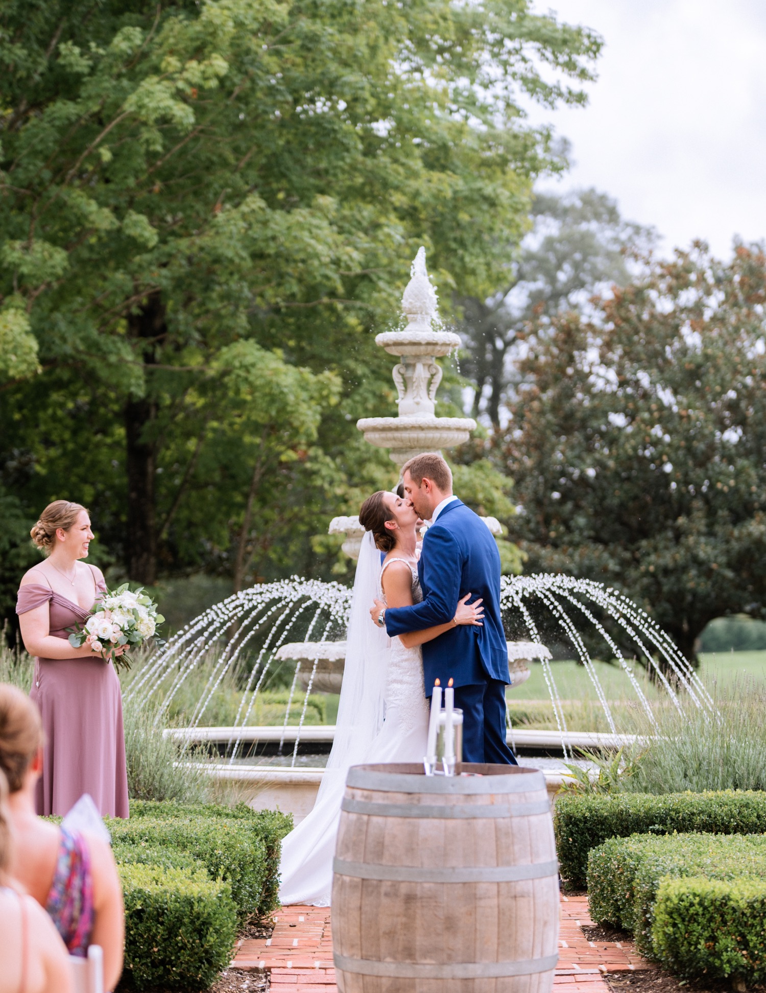 bride and groom kissing at the alter with a fountain behind them