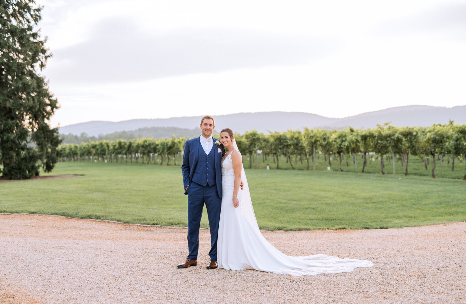 bride and groom walking through keswick vineyards on their wedding day