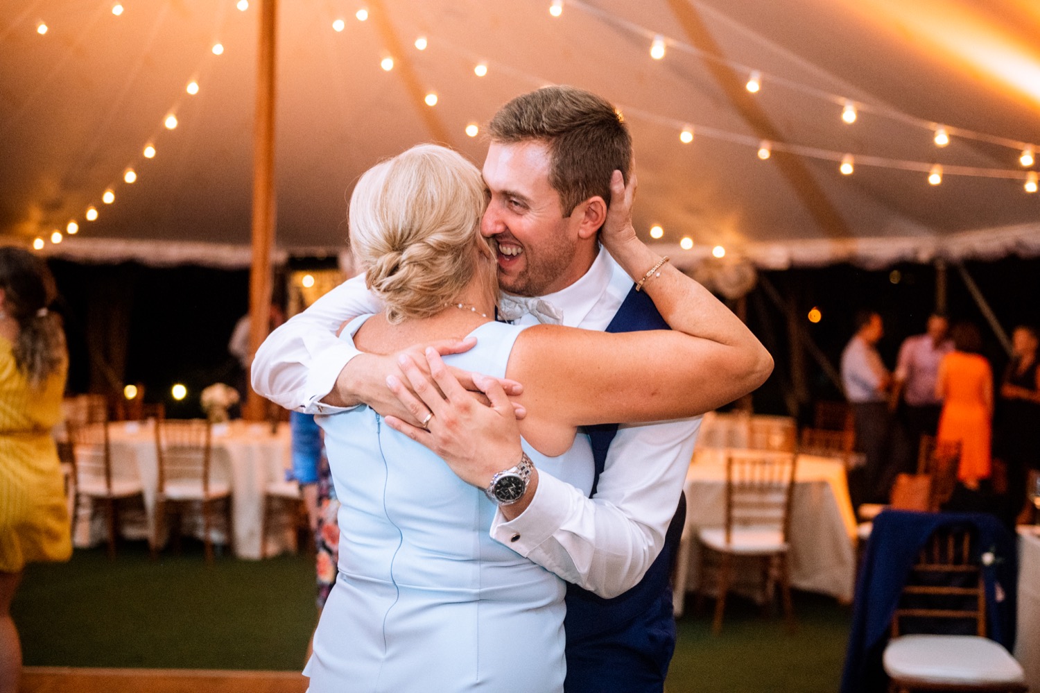 groom hugging and talking with his mom during his wedding reception