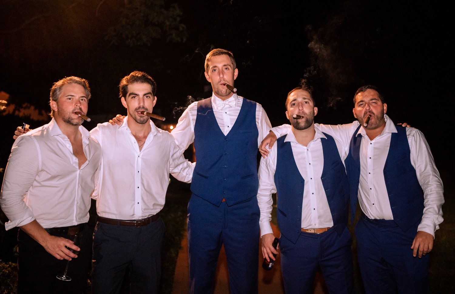 groom and groomsmen smoking cigars at the wedding reception in Charlottesville, Virginia