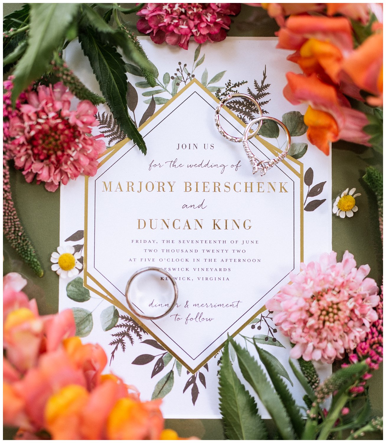 Vibrant wedding invitation for a summer wedding surrounded by pink and orange flowers