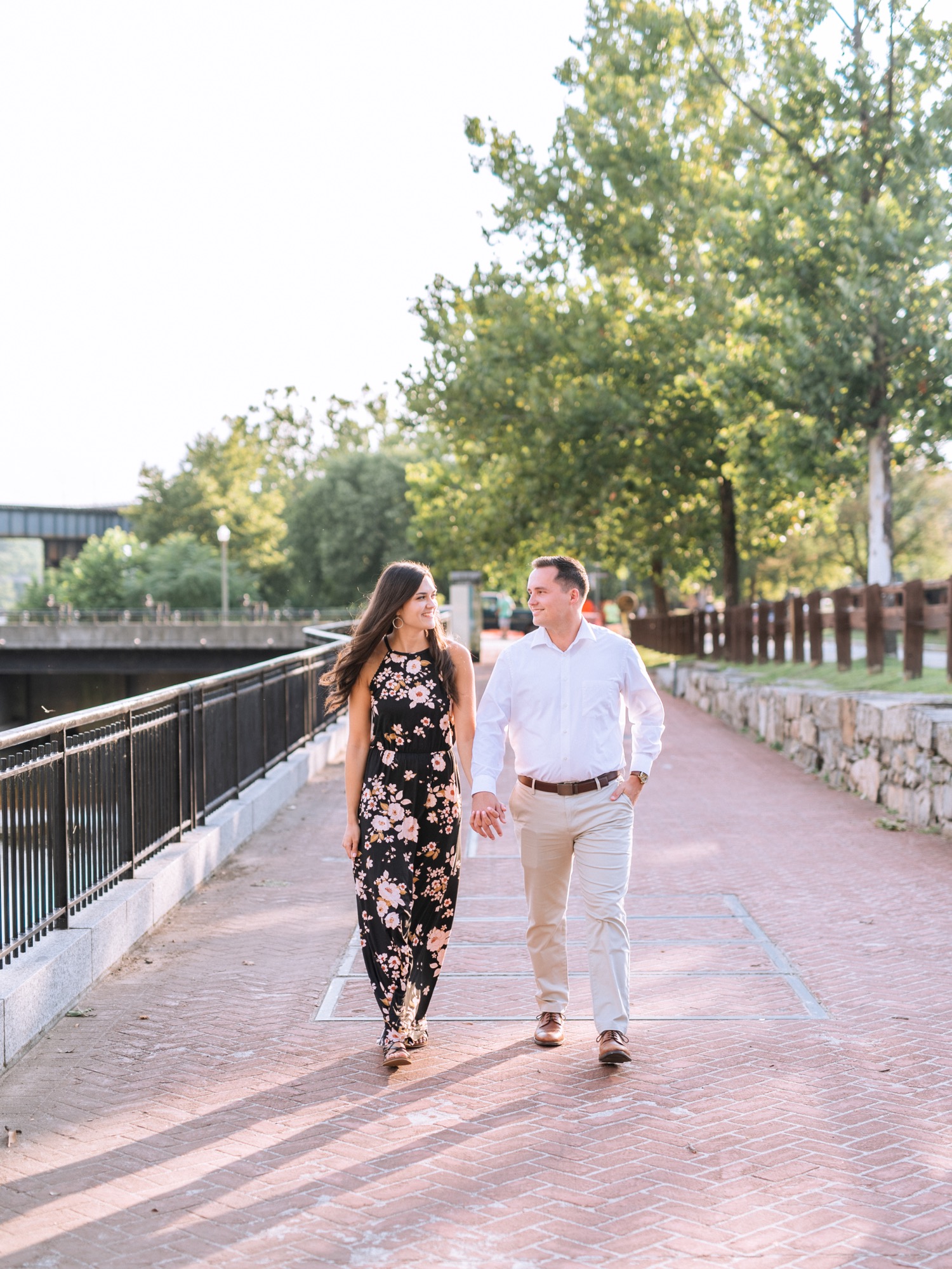 engaged couple walking along waterfront in park on browns island
